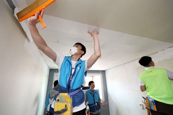 지난 5일 서울 용산구에서 대우건설 임직원들이 노후주택에 도배를 하고 있다