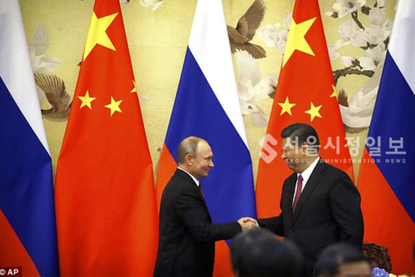 러시아 푸틴 대통령과 중국 시진핑 주석이 서로 축하의 악수를 나누고 있다.