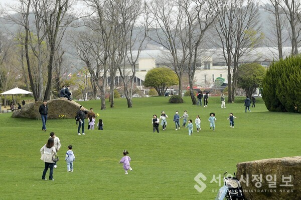 푸른 잔디가 펼쳐진 키즈가든에서 아이들이 뛰어 놀고있다