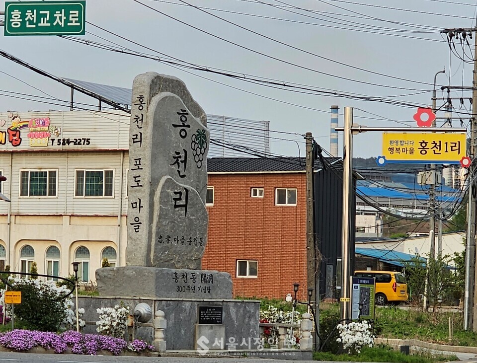 마을 입구에 세워진 표지석. 홍천교차로에 있는 기념비석. 매년 5월말에는 상징인 붉은 꽃 장미축제를 주변에서 진행하고 있다.